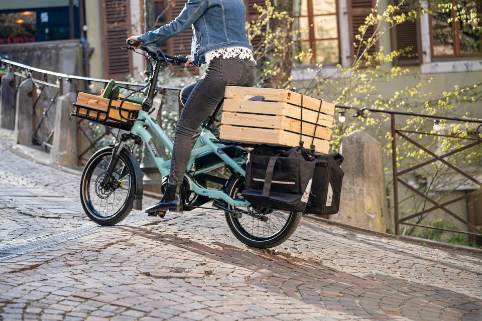 Woman riding a Tern HSD e-bike while carrying cargo