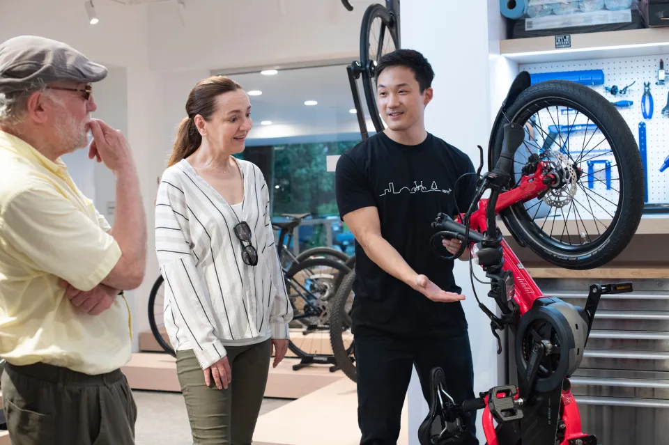 Bike shop staff demonstrating a Tern electric bike to customers during an in-store e-bike consultation.