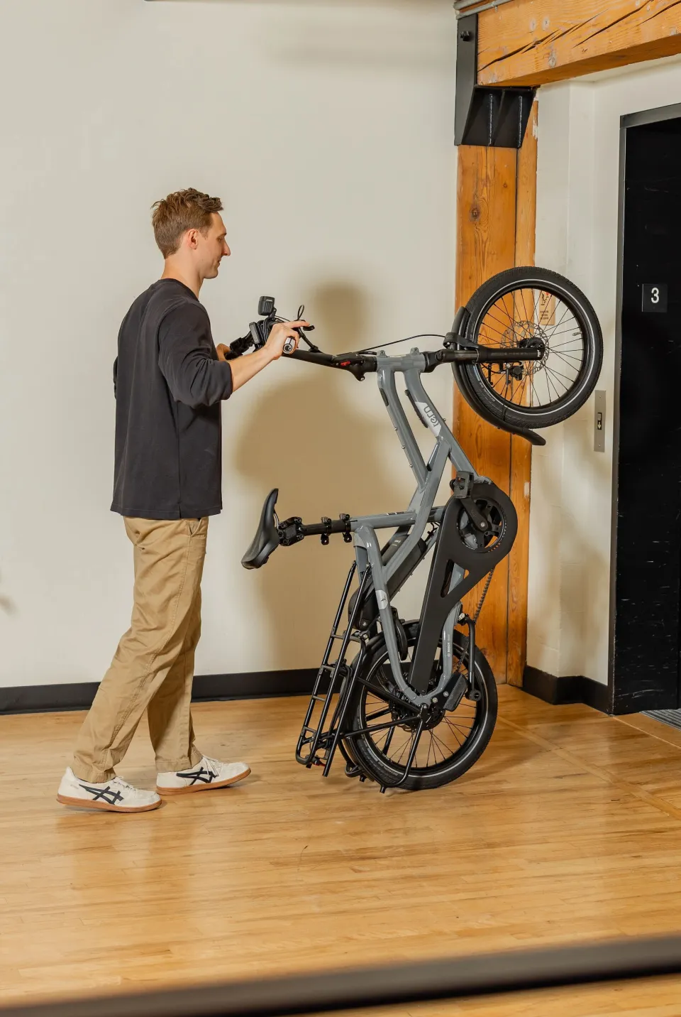 A man rolling a vertical HSD Gen 3 e-cargo bike into the elevator.
