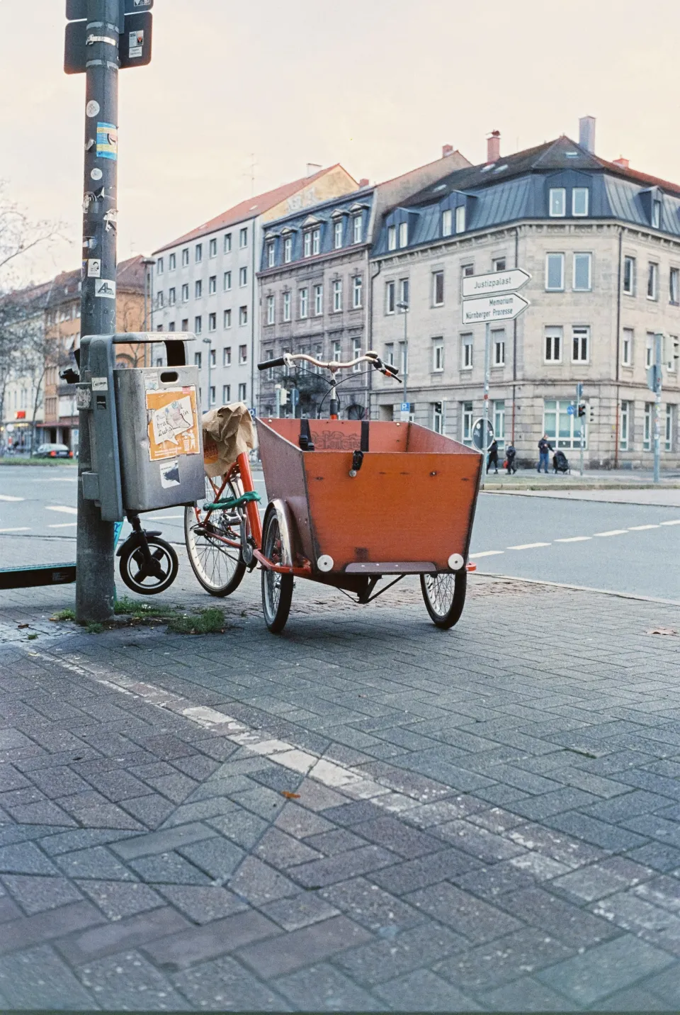 A box bike with a trailer attached to it parked on the side of a street